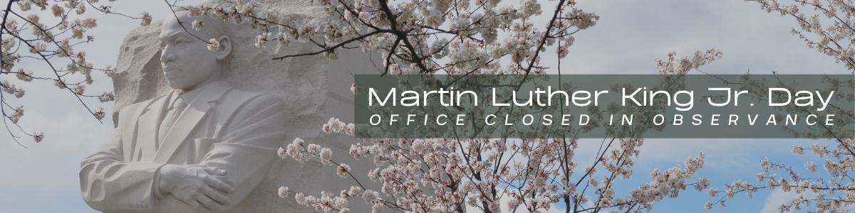 image of Martin Luther King Jr statue with cherry blossoms in the forefront with the text office closed in observance.